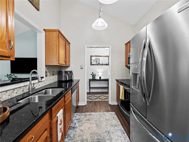 a kitchen with granite countertop a refrigerator stove and sink