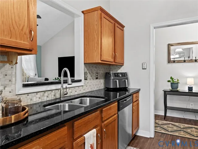 a kitchen with granite countertop a sink stainless steel appliances and cabinets