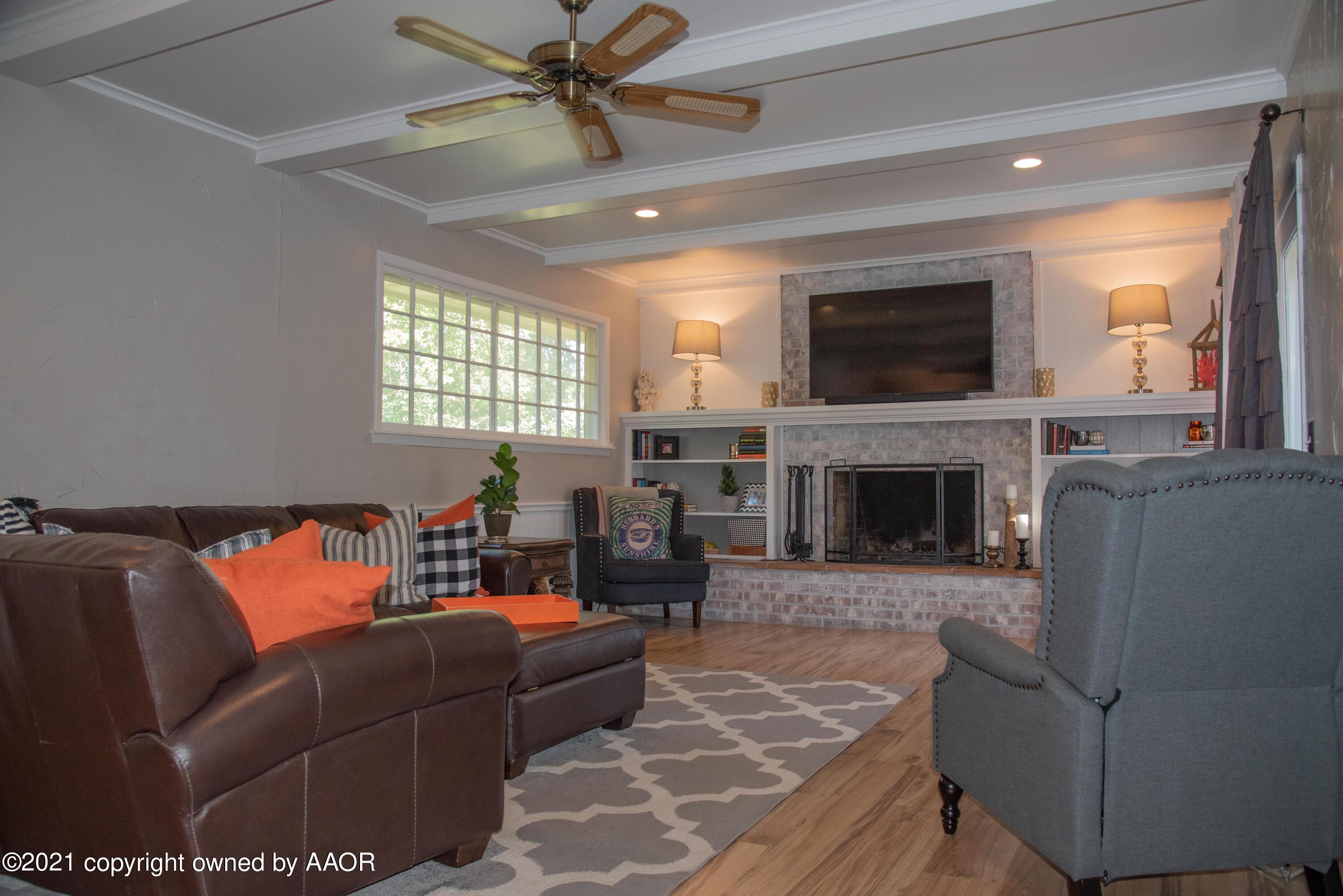 6209 Jameson Road Amarillo, TX 79106 - Photo 12 of 41 a living room with furniture a flat screen tv and a fireplace