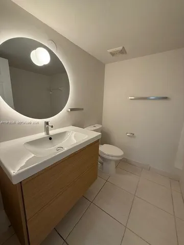 a bathroom with a sink mirror and toilet
