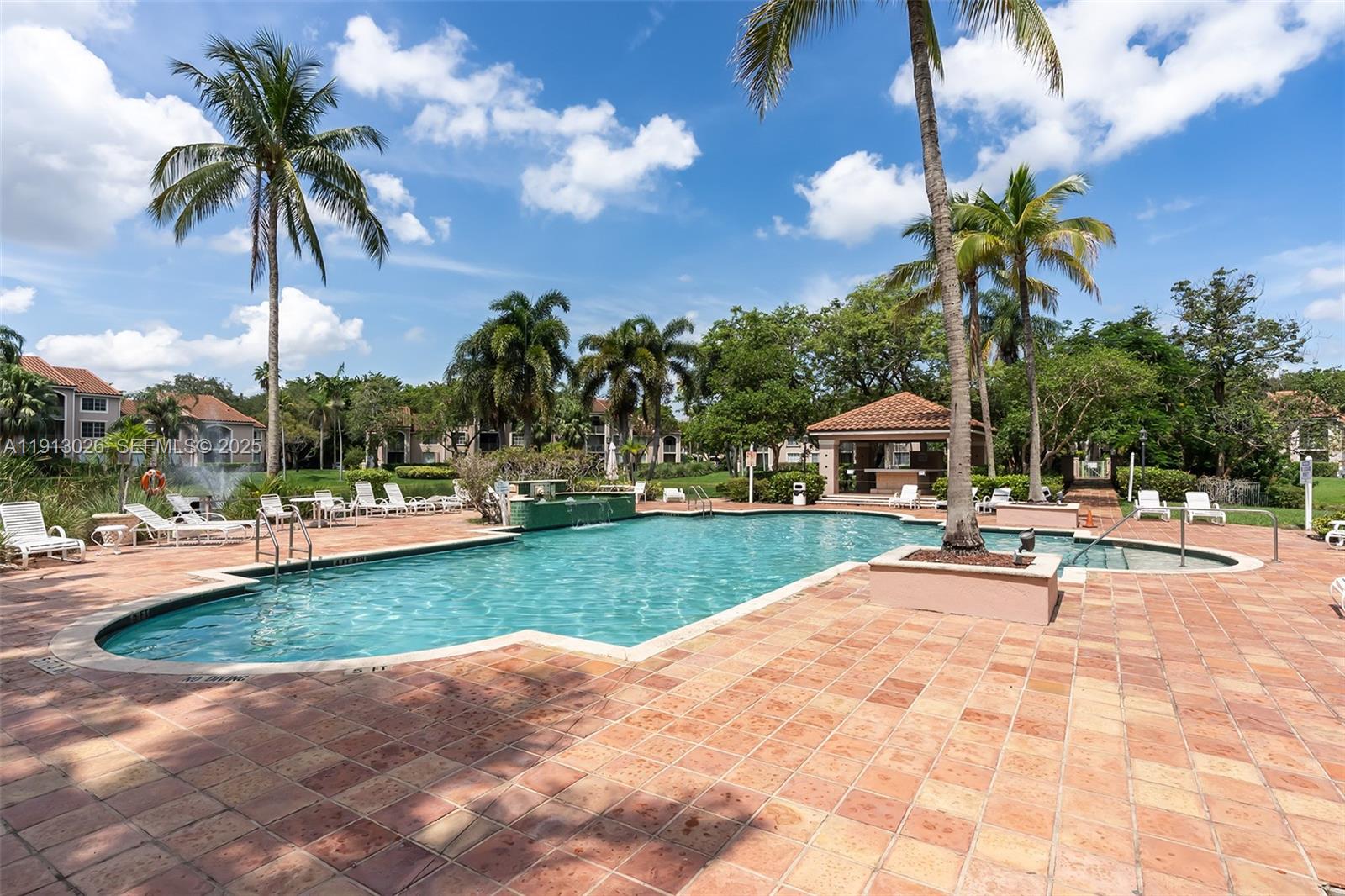 12136 St.Andrews Place, Unit 204 Miramar, FL 33025 - Photo 18 of 21 a view of a patio with a table and chairs under an umbrella