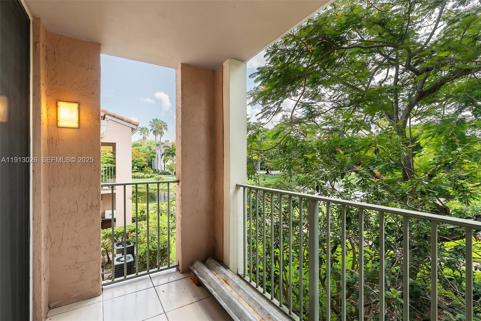 12136 St.Andrews Place, Unit 204 Miramar, FL 33025 - Photo 2 of 21 a balcony with trees in front of it