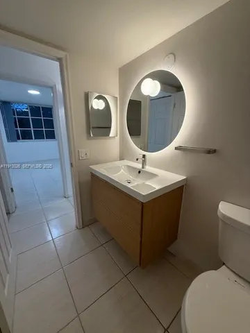 a bathroom with a sink mirror and toilet