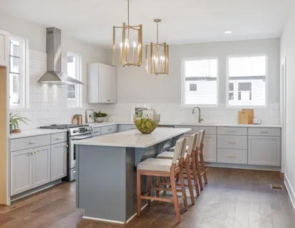 a kitchen with a sink white cabinets and wooden floor