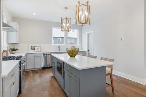 a kitchen with a sink a counter space appliances and cabinets