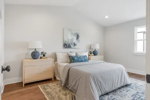 a bedroom with a bed and a painting on the wall