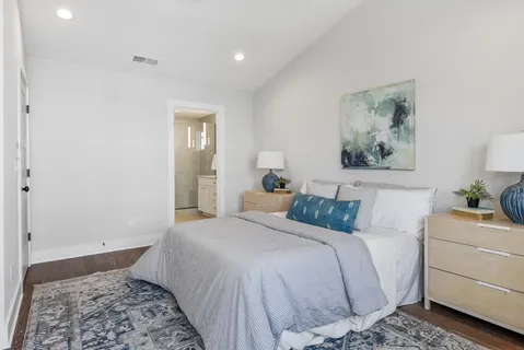 a bedroom with a bed and a painting on the wall