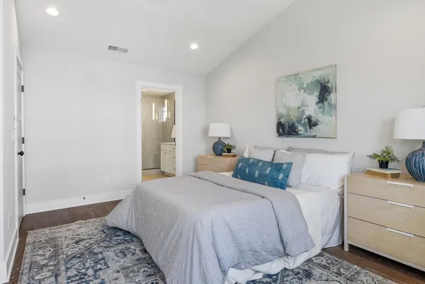 a bedroom with a bed and a painting on the wall