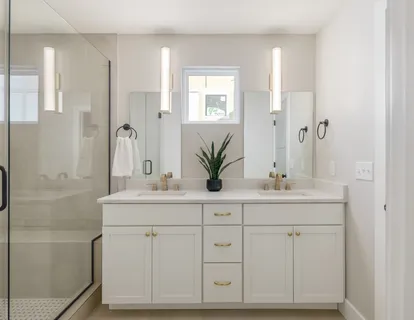 a bathroom with a double vanity sink a large mirror a bathtub and