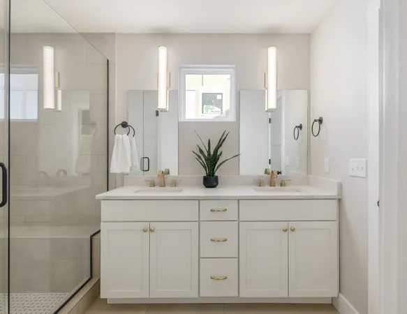 a bathroom with a double vanity sink a large mirror a bathtub and