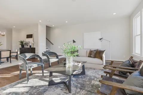 a living room with furniture wooden floor and a window