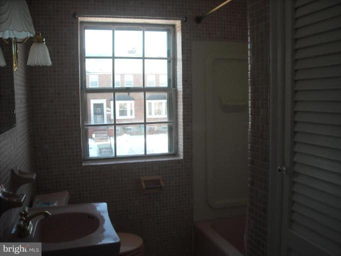 5741 Edgepark Road Baltimore, MD 21239 - Photo 13 of 16 a bathroom with a sink toilet and window
