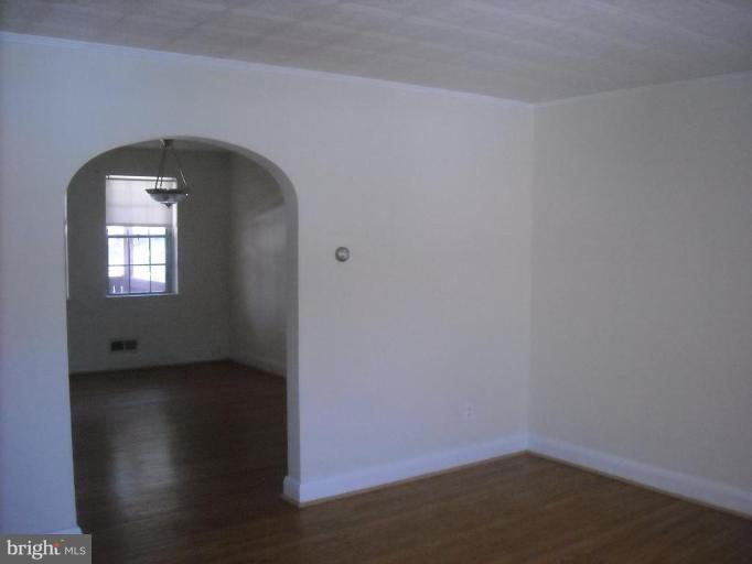 5741 Edgepark Road Baltimore, MD 21239 - Photo 8 of 16 a view of empty room with wooden floor and fan