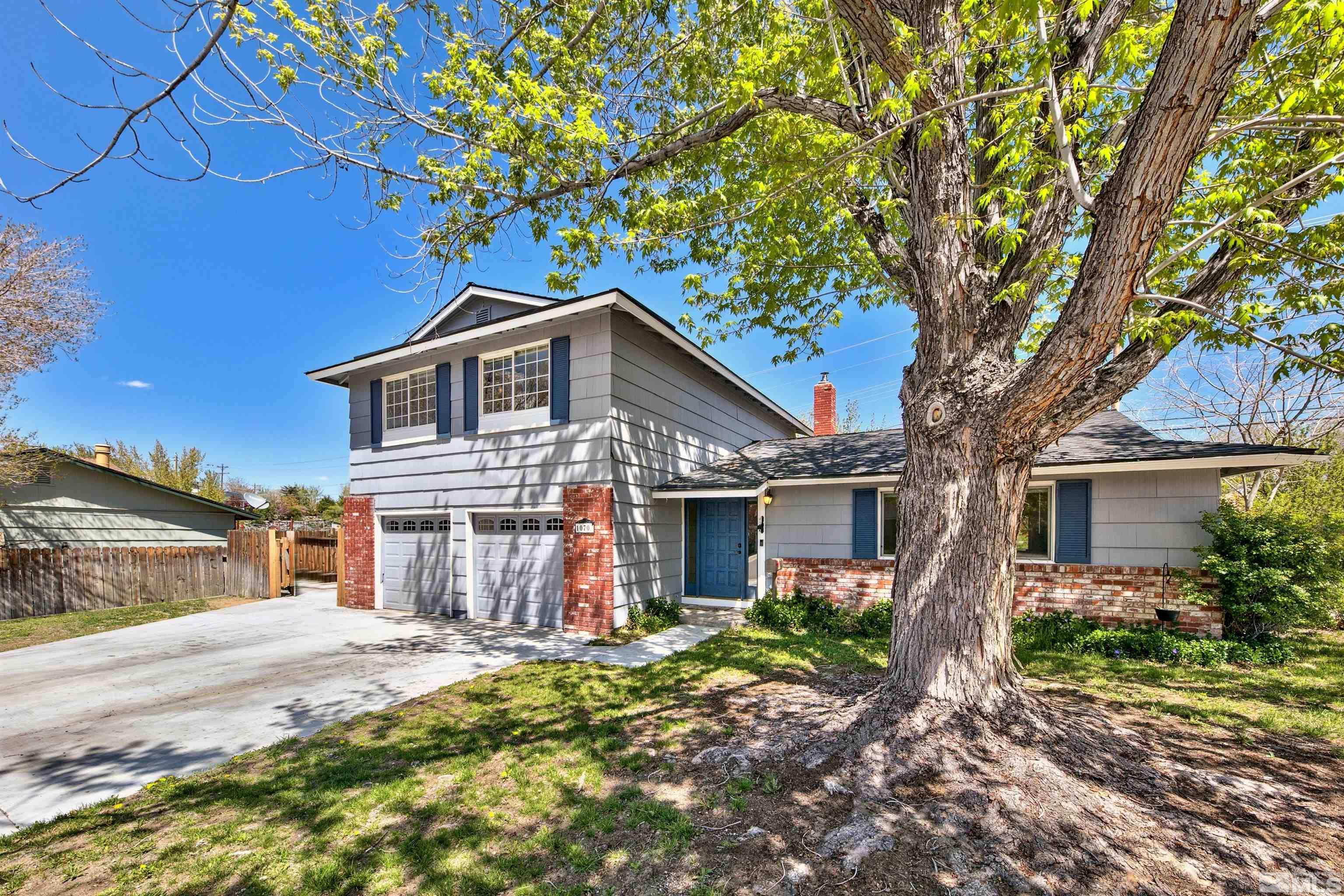 a front view of a house with a tree