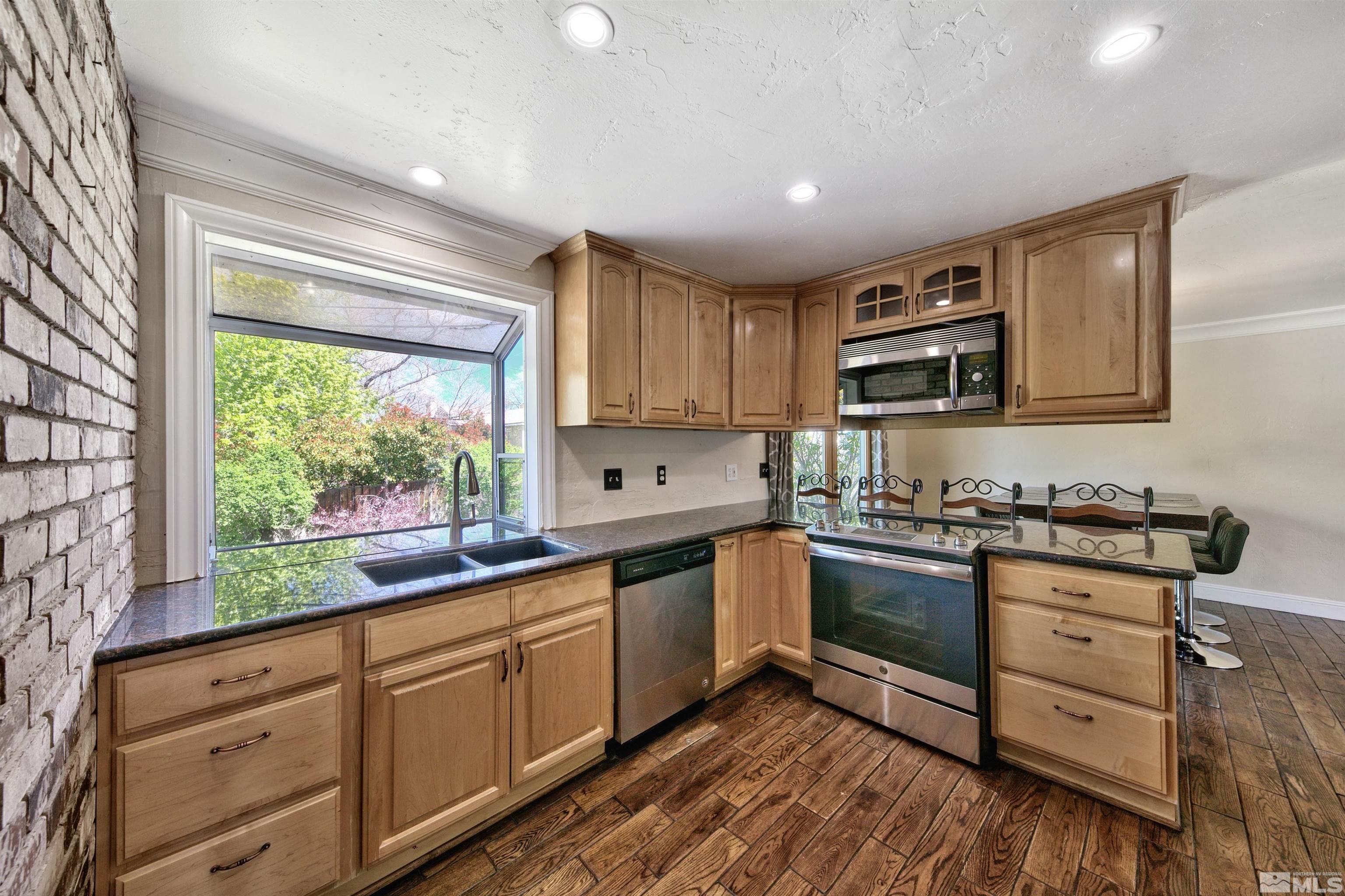 1070 Mark Allen Circle Reno, NV 89503 - Photo 6 of 11 a kitchen with granite countertop cabinets stainless steel appliances a sink and a window