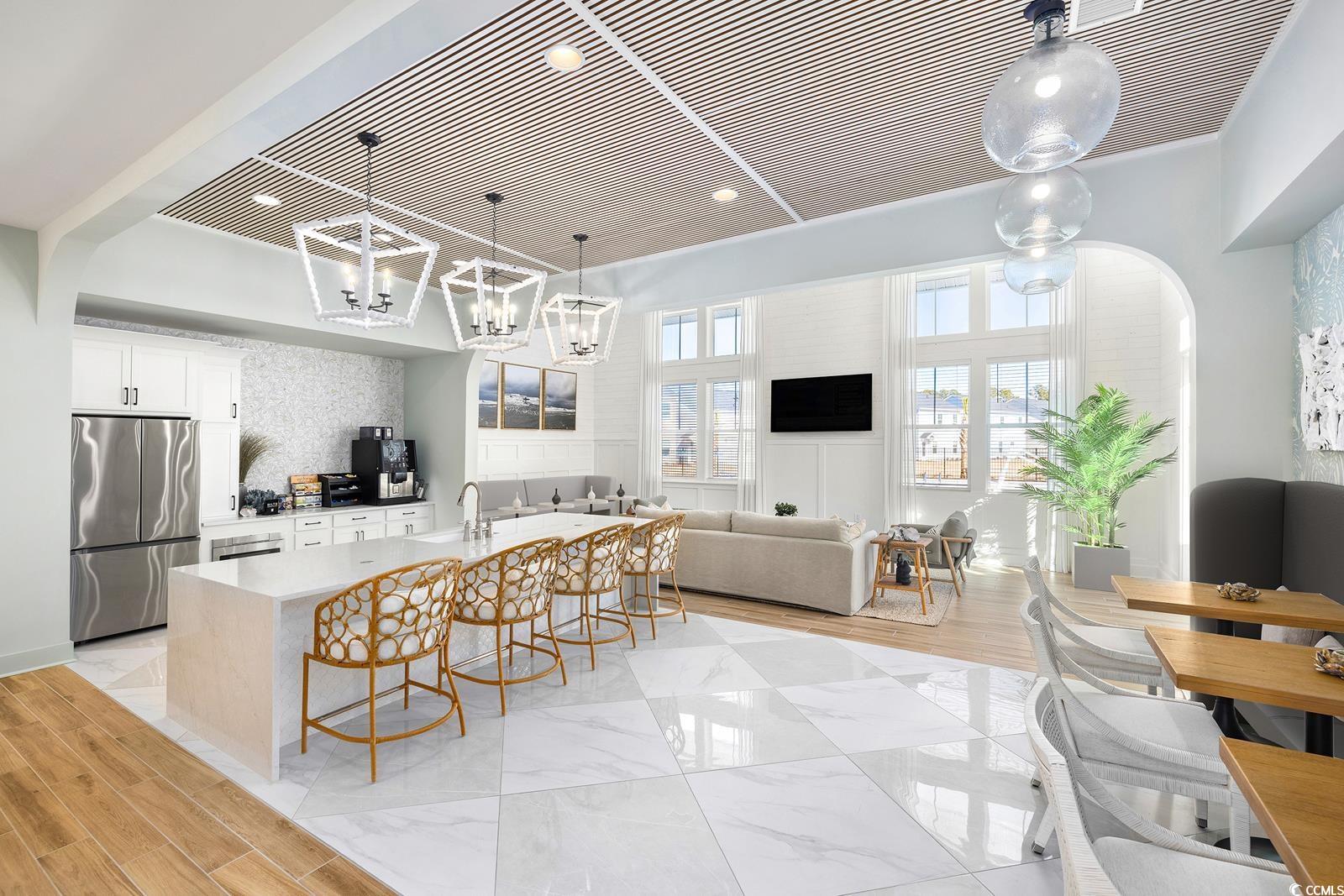 283 Ferretti Street, Unit CONCORD Myrtle Beach, SC 29579 - Photo 11 of 34 Kitchen with freestanding refrigerator, a kitchen bar, a chandelier, hanging light fixtures, and light countertops