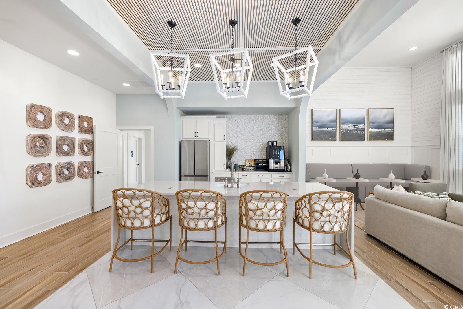 283 Ferretti Street, Unit CONCORD Myrtle Beach, SC 29579 - Photo 12 of 34 Kitchen featuring freestanding refrigerator, a kitchen breakfast bar, a large island, white cabinets, and recessed lighting