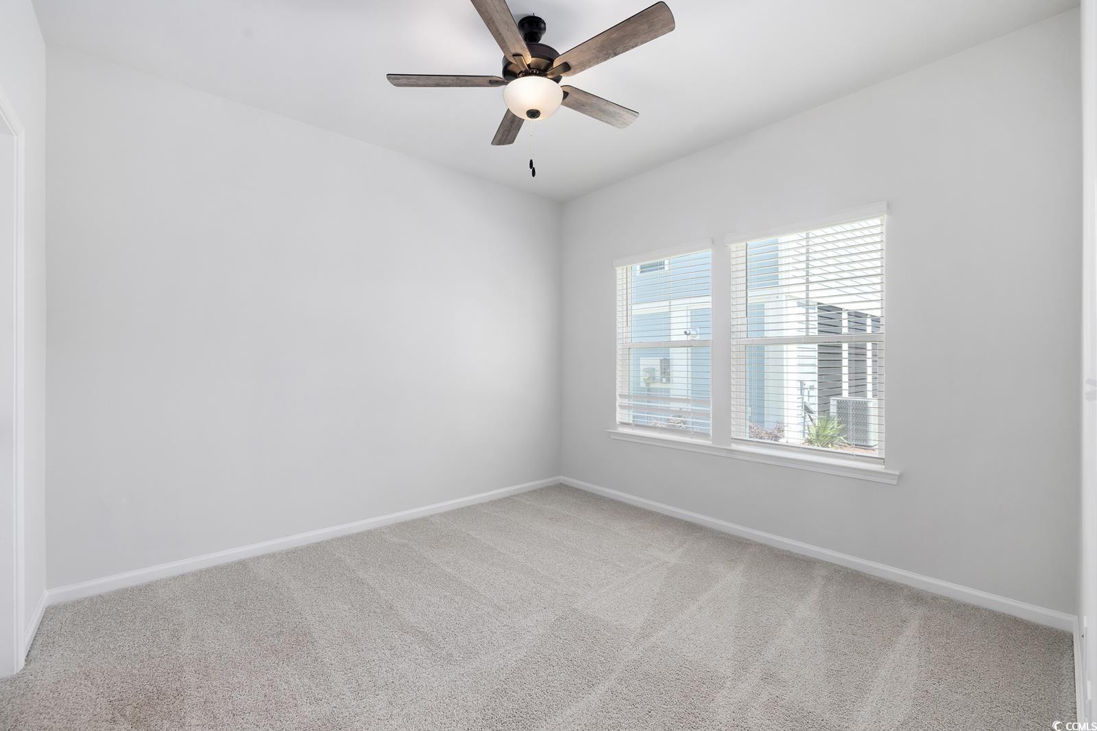 283 Ferretti Street, Unit CONCORD Myrtle Beach, SC 29579 - Photo 23 of 34 Empty room featuring carpet flooring, baseboards, and a ceiling fan
