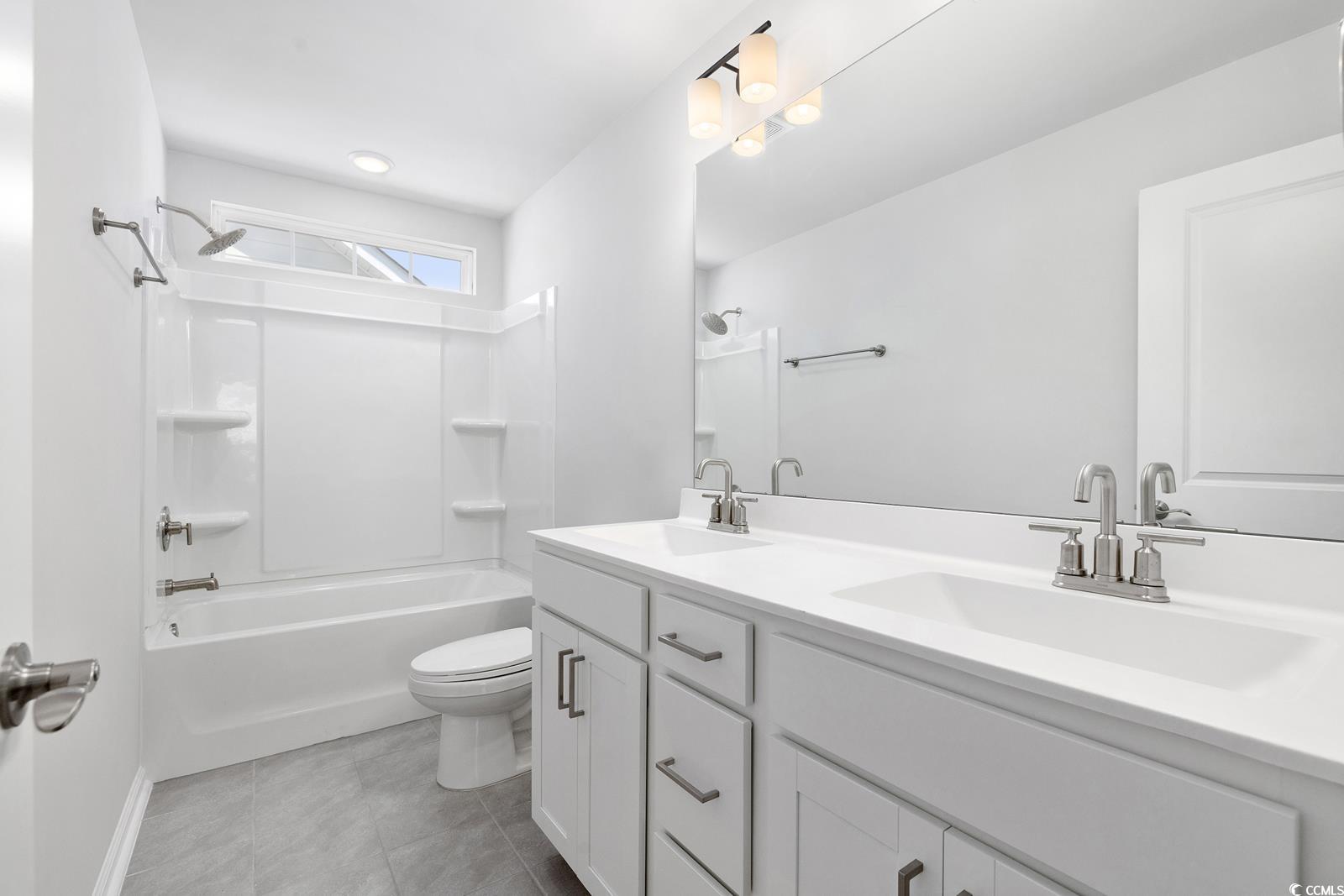283 Ferretti Street, Unit CONCORD Myrtle Beach, SC 29579 - Photo 24 of 34 Full bath with toilet, double vanity, bathing tub / shower combination, tile patterned flooring, and baseboards
