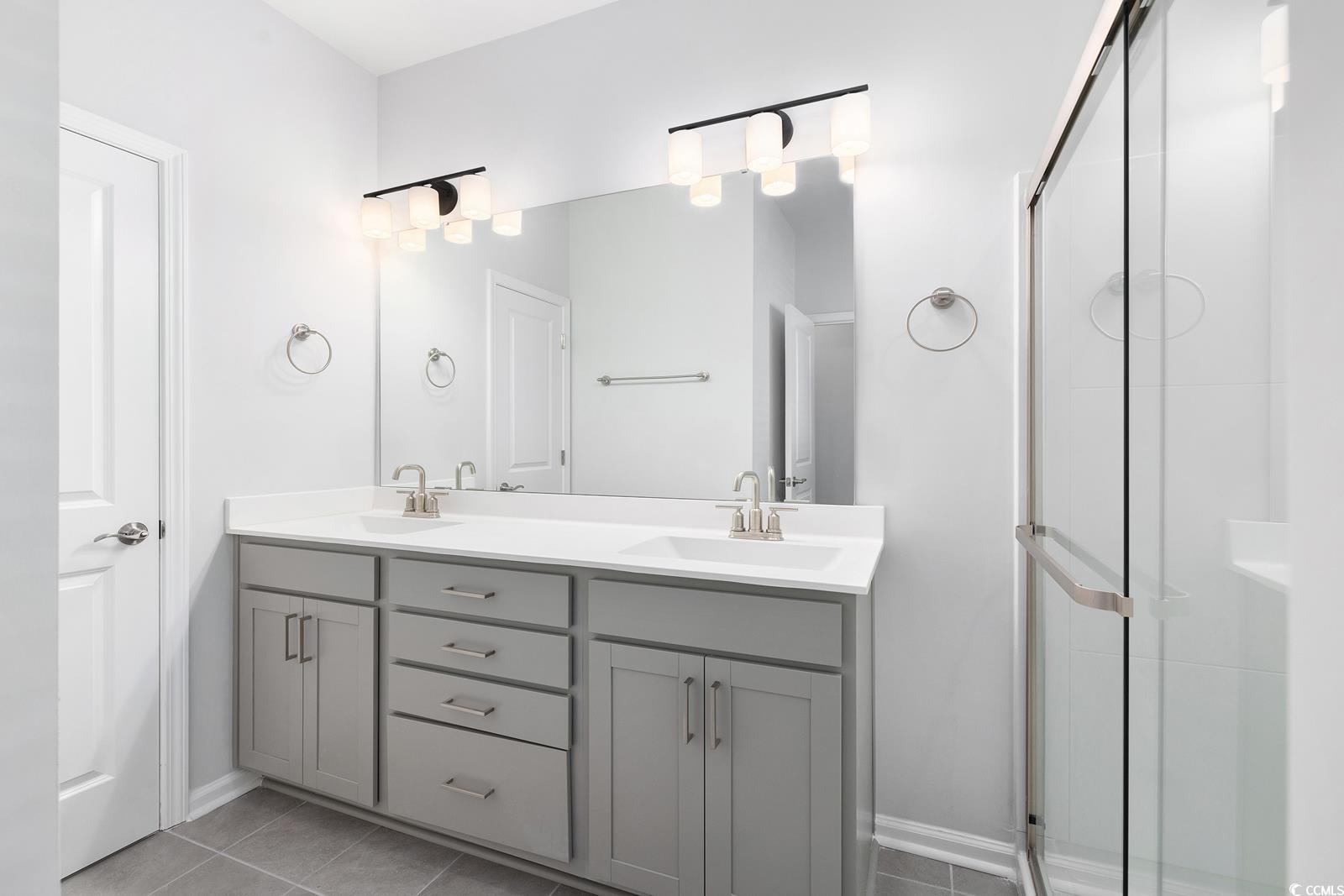 283 Ferretti Street, Unit CONCORD Myrtle Beach, SC 29579 - Photo 25 of 34 Bathroom with a stall shower, double vanity, tile patterned flooring, and baseboards