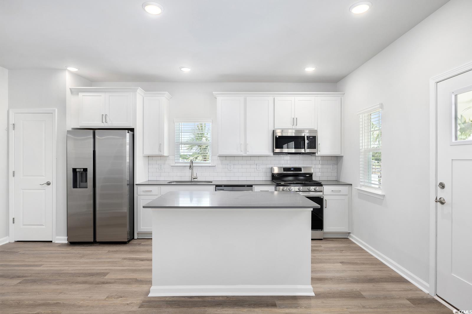 283 Ferretti Street, Unit CONCORD Myrtle Beach, SC 29579 - Photo 26 of 34 Kitchen featuring stainless steel appliances, a sink, white cabinets, backsplash, and recessed lighting