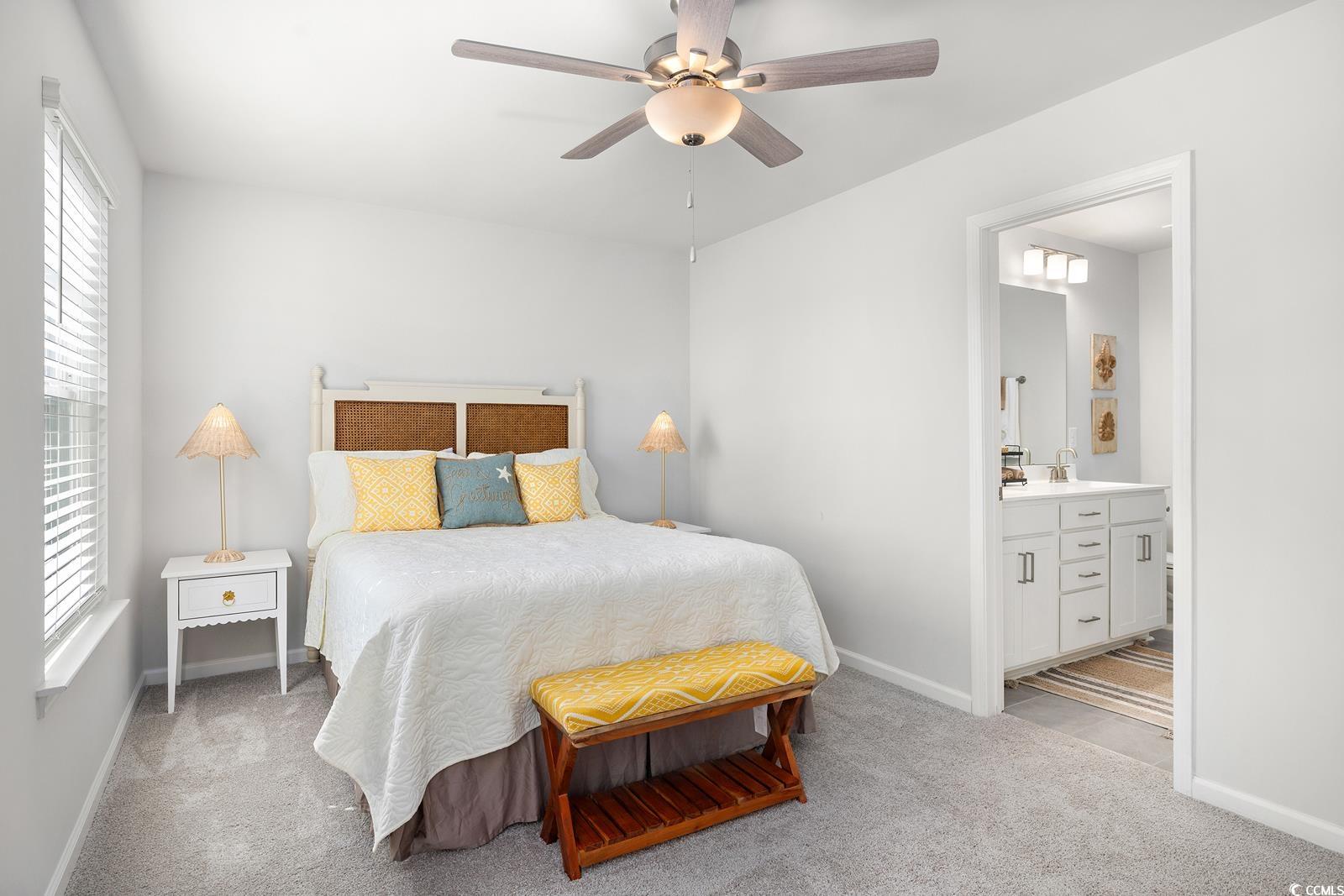 283 Ferretti Street, Unit CONCORD Myrtle Beach, SC 29579 - Photo 6 of 34 Bedroom featuring connected bathroom, carpet flooring, baseboards, and ceiling fan