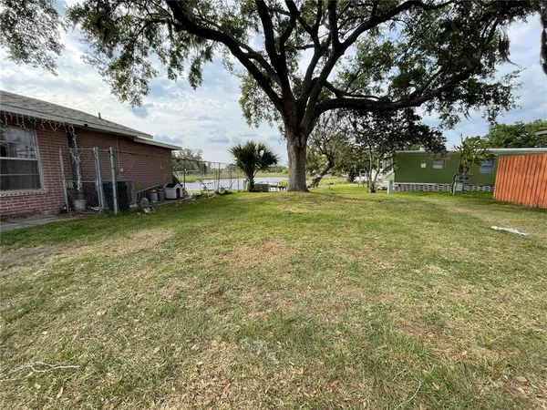 a view of a yard with a house and a large tree