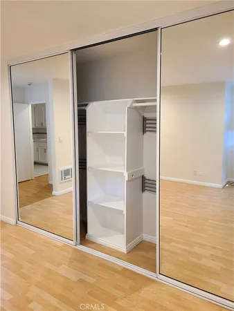 a view of empty room with wooden floor and cabinet