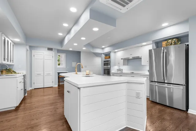a dining room with furniture large windows and wooden floor
