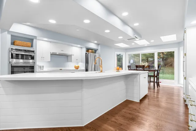 a spacious bedroom with a bed next to a large window with wooden floor