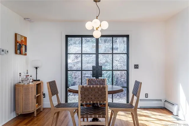 a view of a dining room with furniture a chandelier and wooden floor