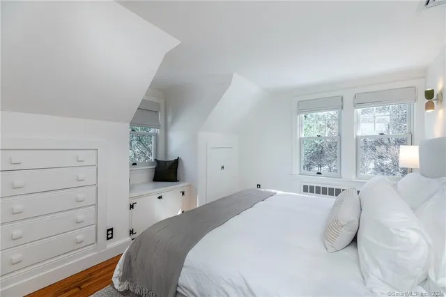 a bedroom with a large bed and a tv on the dresser