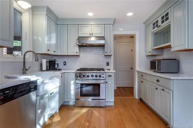 a kitchen with stainless steel appliances granite countertop a stove a sink dishwasher and a refrigerator