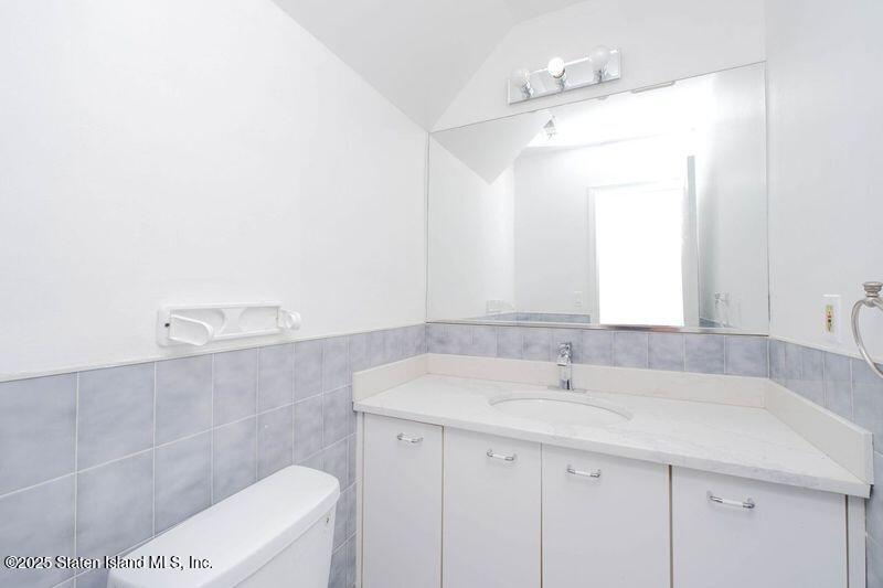 23 Vogel Loop Staten Island, NY 10314 - Photo 13 of 24 a bathroom with a sink a toilet and a mirror