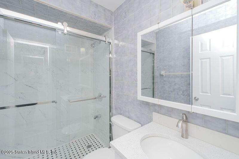 23 Vogel Loop Staten Island, NY 10314 - Photo 15 of 24 a bathroom with a sink toilet and shower