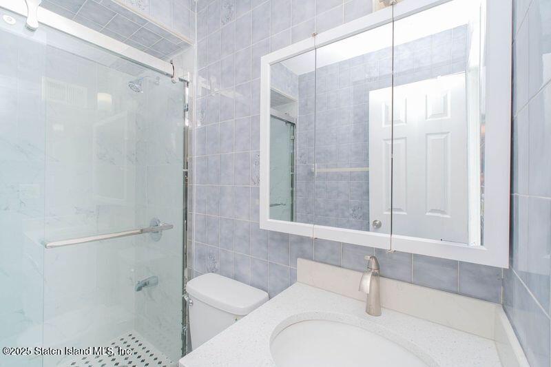 23 Vogel Loop Staten Island, NY 10314 - Photo 16 of 24 a bathroom with a granite countertop bathtub shower and toilet
