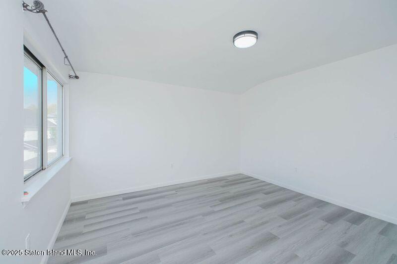 23 Vogel Loop Staten Island, NY 10314 - Photo 17 of 24 a view of a room that has wooden floor and window