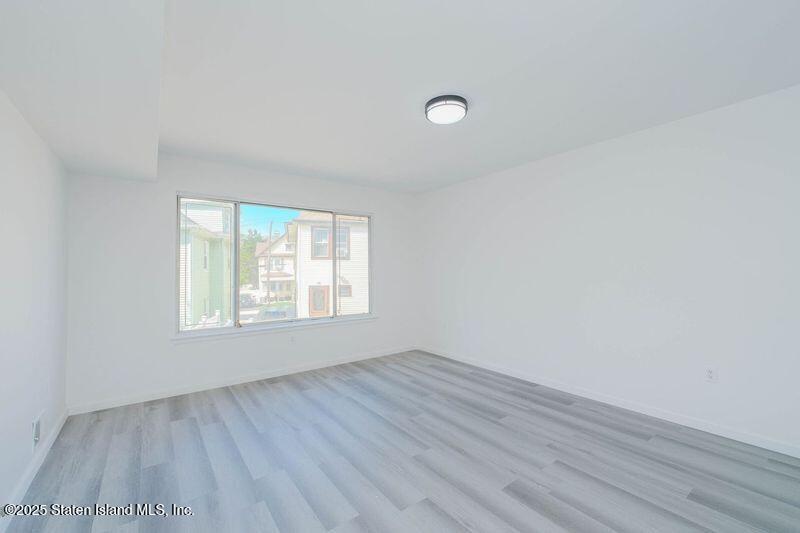 23 Vogel Loop Staten Island, NY 10314 - Photo 18 of 24 an empty room with wooden floor and windows