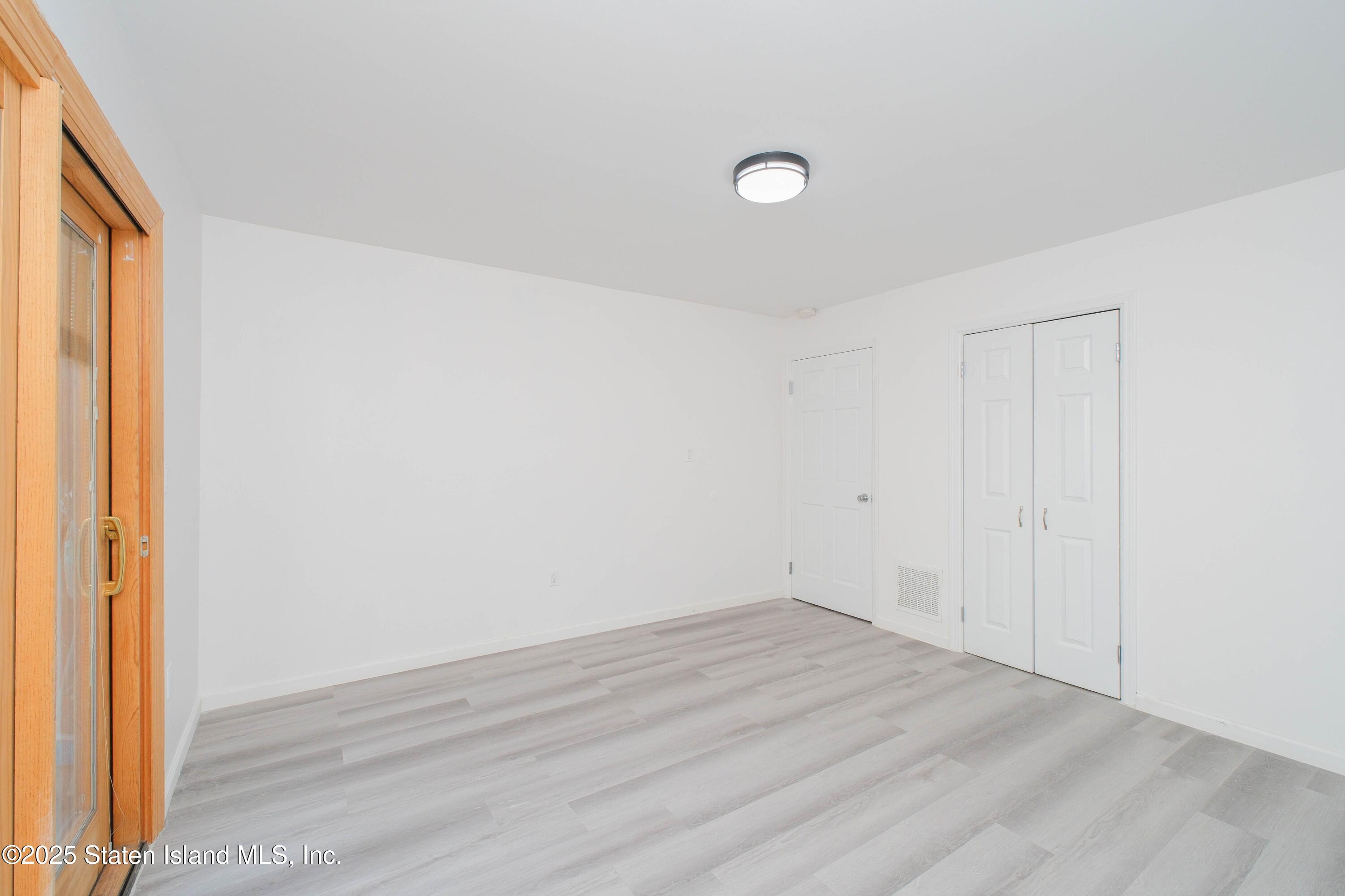 23 Vogel Loop Staten Island, NY 10314 - Photo 3 of 24 a view of a room with wooden floor and white walls