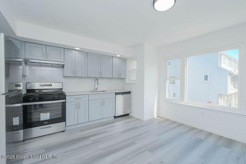 23 Vogel Loop Staten Island, NY 10314 - Photo 7 of 24 a kitchen with granite countertop a stove and a sink