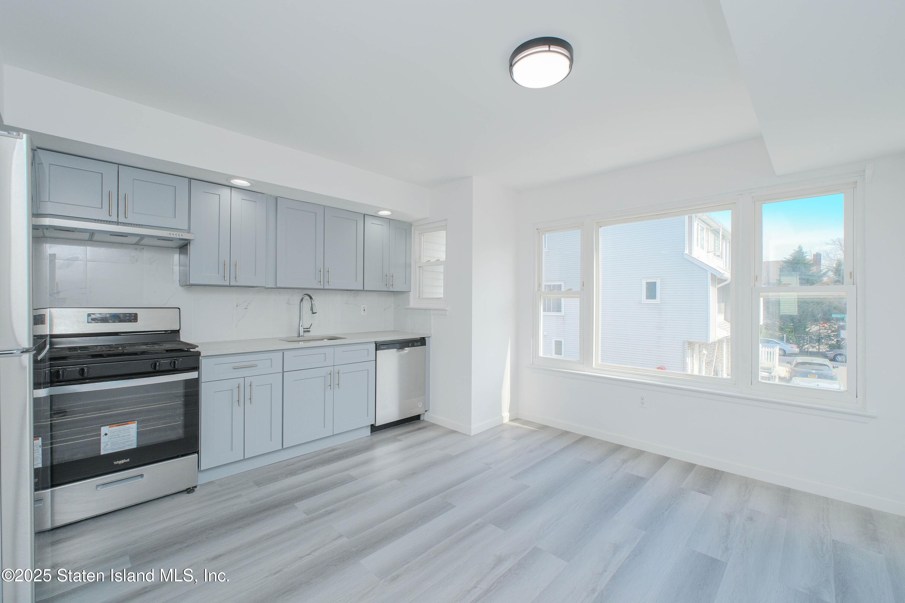 23 Vogel Loop Staten Island, NY 10314 - Photo 10 of 24 a kitchen with granite countertop white cabinets and stainless steel appliances