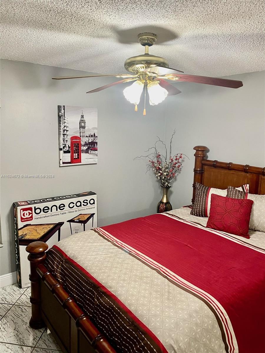 Goulds Miami, FL 33177 - Photo 13 of 18 a bedroom with a bed and a chandelier