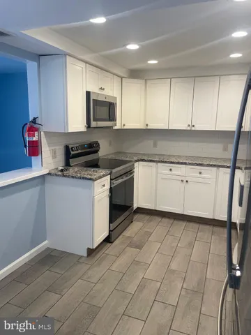a kitchen with stainless steel appliances granite countertop a sink and a stove