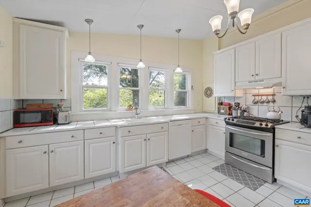 a kitchen with granite countertop white cabinets white appliances with a sink and dishwasher