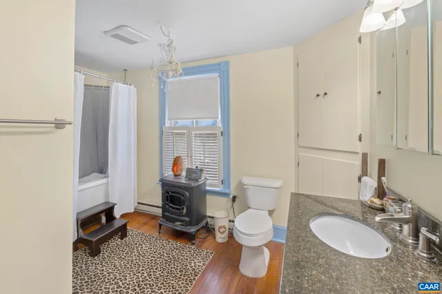 a bathroom with a sink toilet a mirror and shower