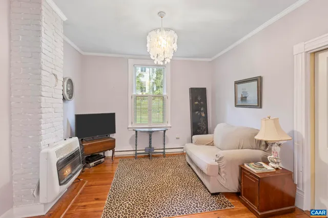 a living room with furniture a chandelier and a flat screen tv