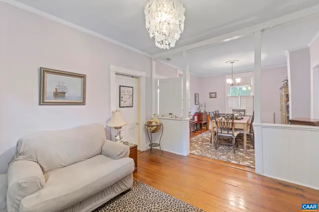 a living room with furniture a dining table and a chandelier