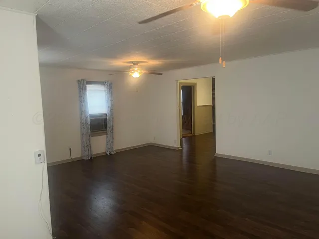 an empty room with wooden floor & closet area