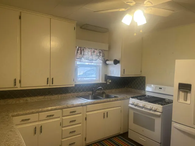 a kitchen with granite countertop cabinets stainless steel appliances and a sink