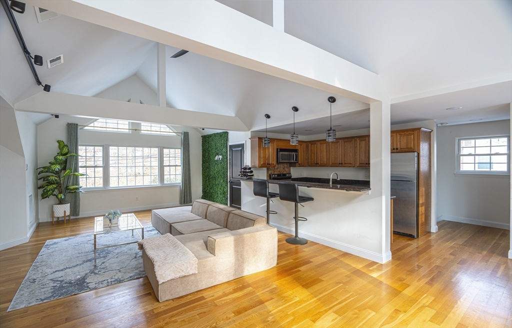 a living room with furniture flat screen tv and wooden floor